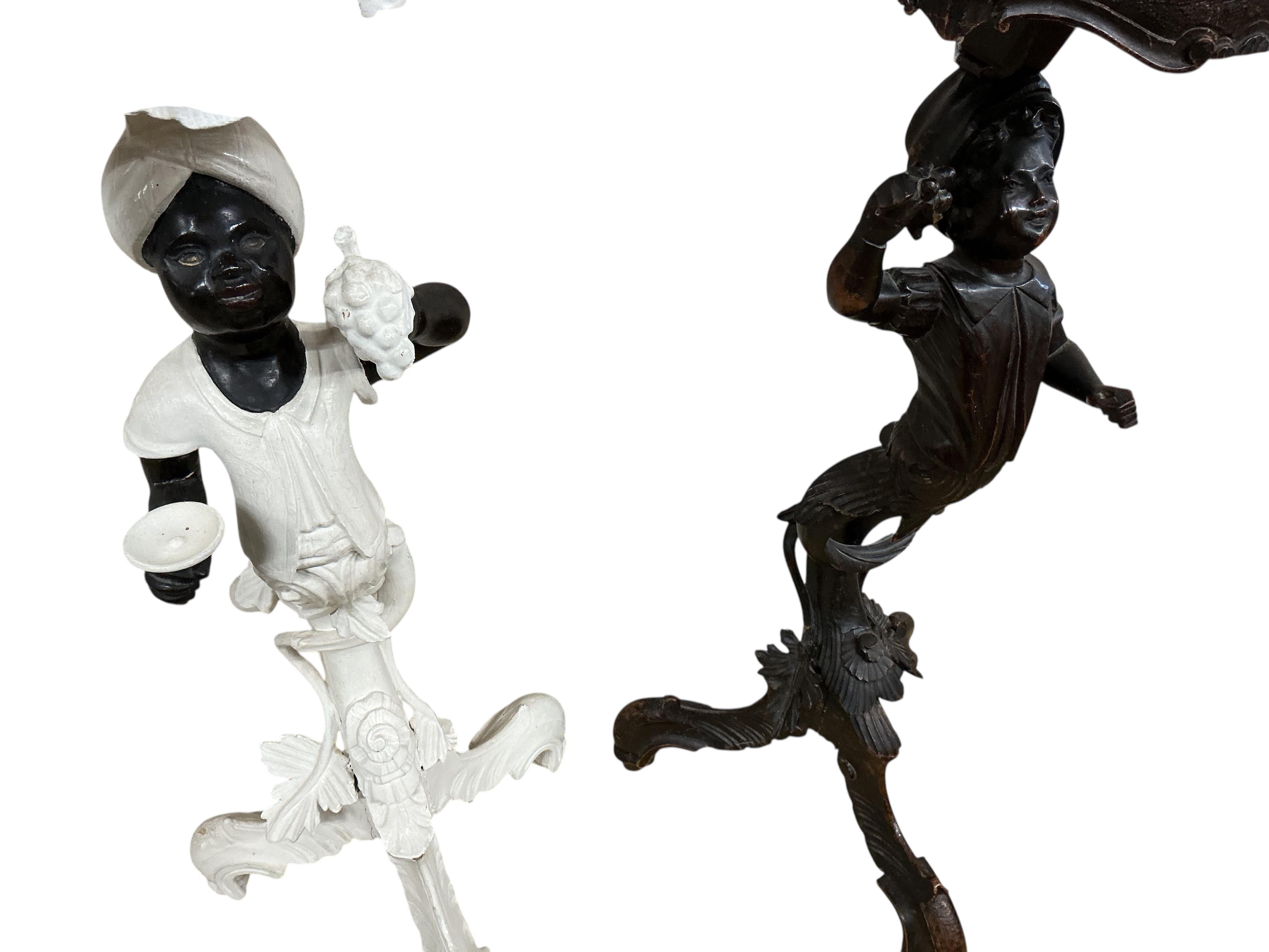 A near pair of Italian carved walnut Blackamoor torcheres, one later painted, larger 94cm